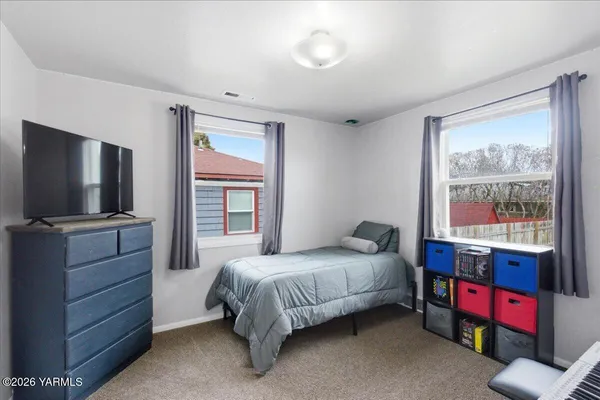 a room that has a dresser and a flat screen tv