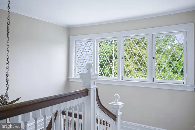 a view of a brick house with a large windows and flower plants