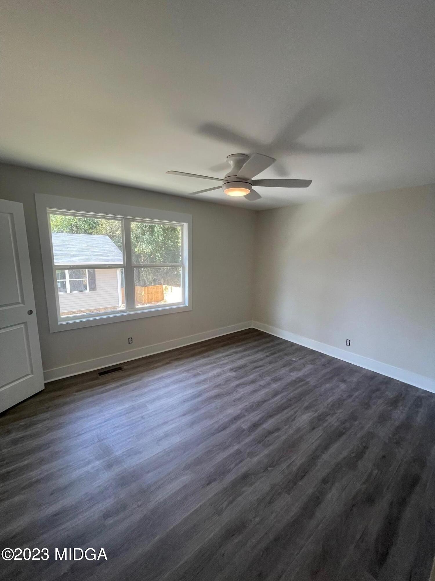2375 Parker Avenue, Unit 2 Macon, GA 31204 - Photo 4 of 16 an empty room with wooden floor fan and windows