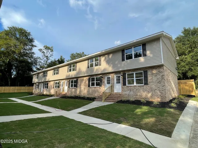 a view of an empty room with wooden floor and closet area