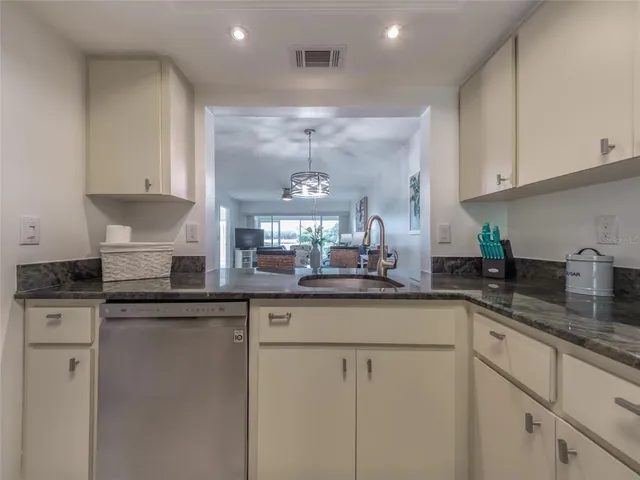 a kitchen with granite countertop a sink and cabinets