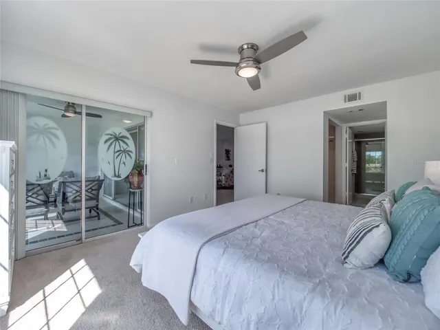 a spacious bedroom with a bed and a chandelier