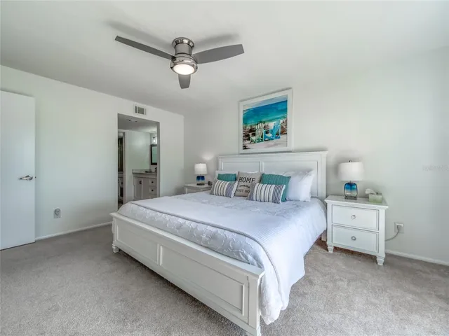 a spacious bedroom with a bed and a ceiling fan
