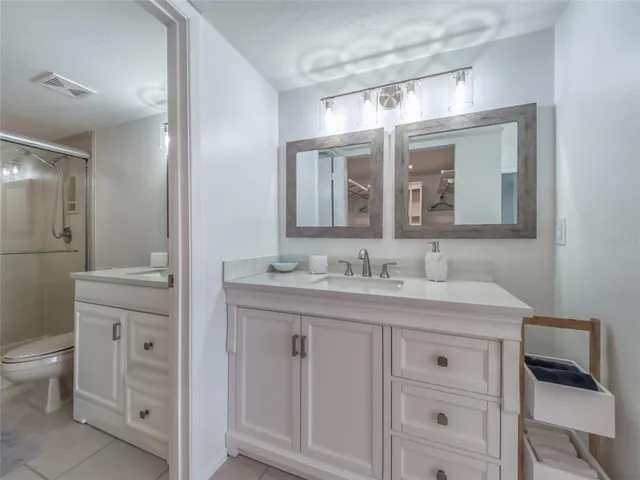 a bathroom with a granite countertop sink mirror and a toilet