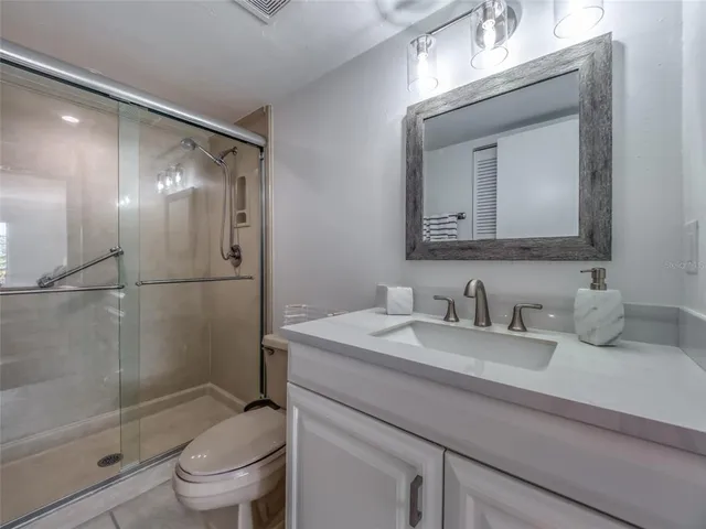 a bathroom with a granite countertop sink mirror toilet and bathtub