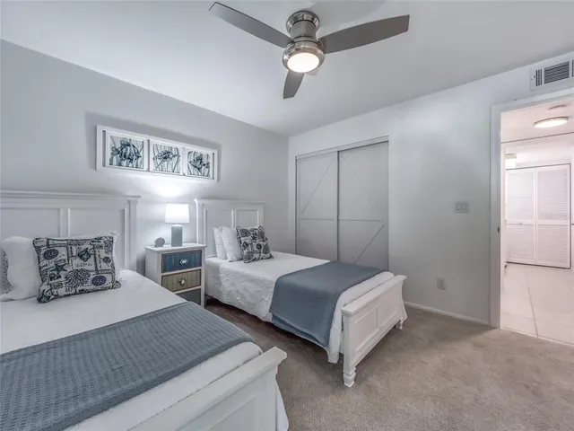 a bedroom with two beds and ceiling fan