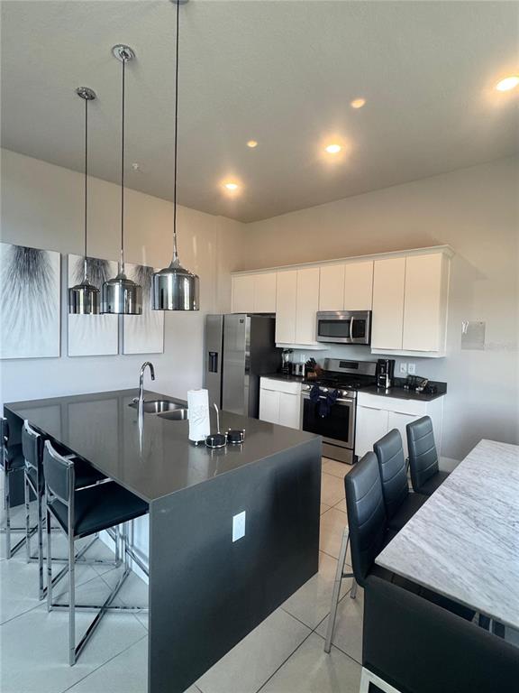7770 Sandy Ridge Drive, Unit 210 Reunion, FL 34747 - Photo 4 of 42 a kitchen with stainless steel appliances granite countertop a stove top oven a sink a dining table and chairs