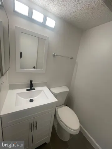 a bathroom with a sink a toilet and mirror