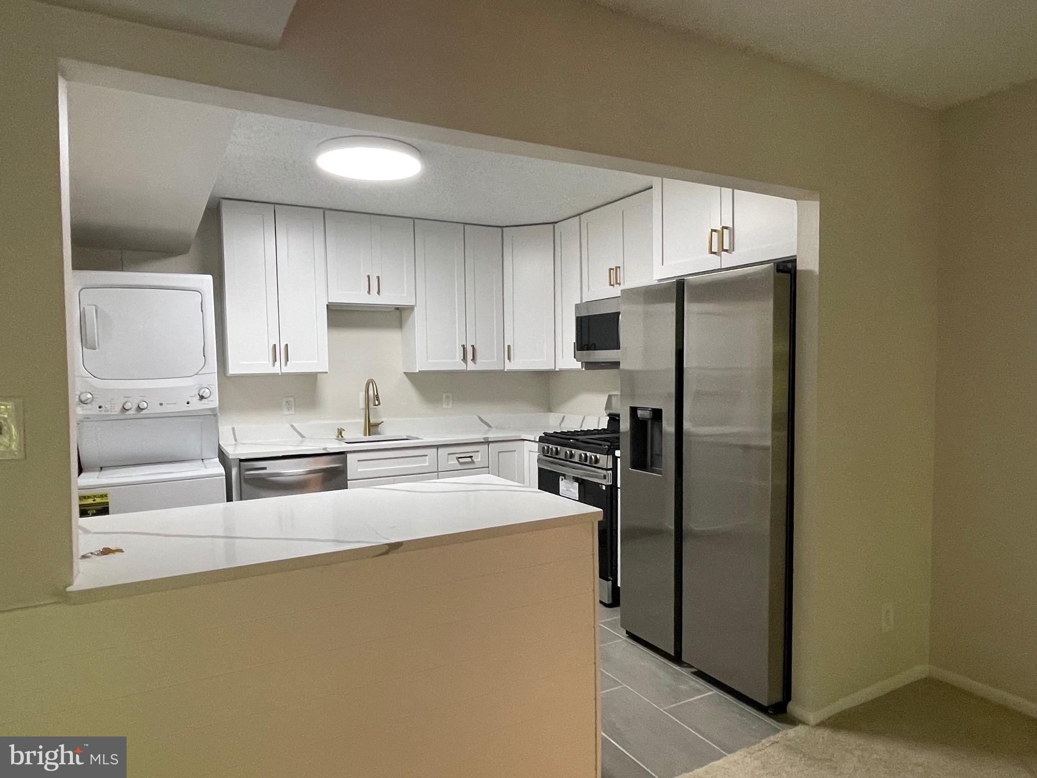 11837 Shire Court, Unit 22 Reston, VA 20191 - Photo 4 of 14 a kitchen with stainless steel appliances granite countertop a refrigerator a stove and a sink