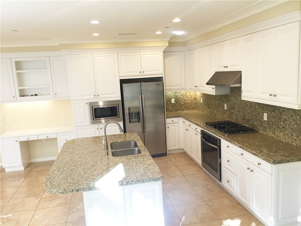 36 Brindisi Irvine, CA 92618 - Photo 4 of 44 a kitchen with stainless steel appliances granite countertop a sink and a stove