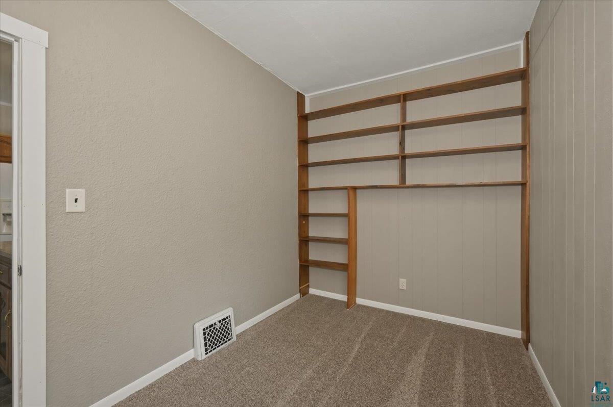 5319 East 3rd Street Superior, WI 54880 - Photo 12 of 33 Built-in wood shelving and wood-look paneling complement the carpeted flooring and neutral wall tones