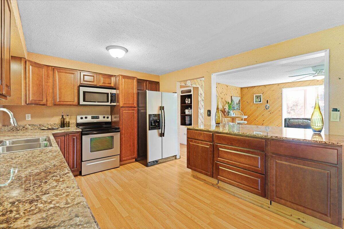 4093 Old Upton Road Central Point, OR 97502 - Photo 6 of 23 a kitchen with stainless steel appliances kitchen island granite countertop a stove a sink and a refrigerator