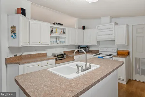a kitchen with stainless steel appliances granite countertop a sink a stove and a refrigerator