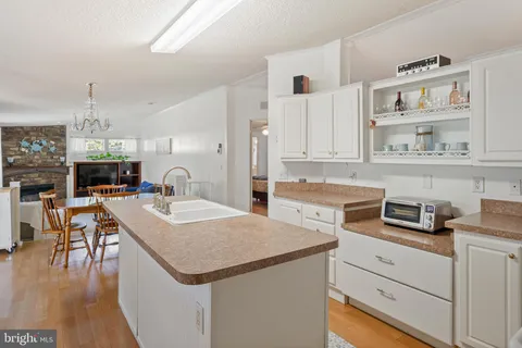 a kitchen that has a sink a table and chairs in it