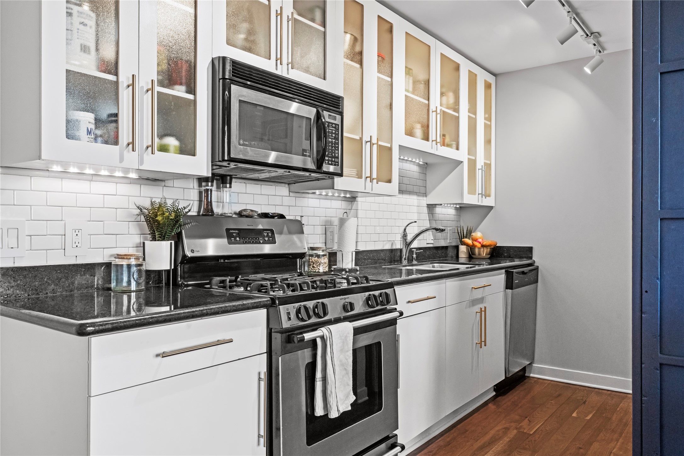 915 Franklin Street, Unit 8J Houston, TX 77002 - Photo 12 of 12 a kitchen with stainless steel appliances granite countertop a stove and a microwave