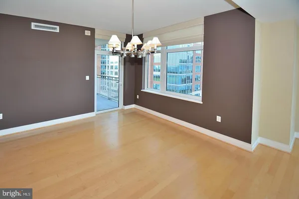 a view of a livingroom with a chandelier fan and windows