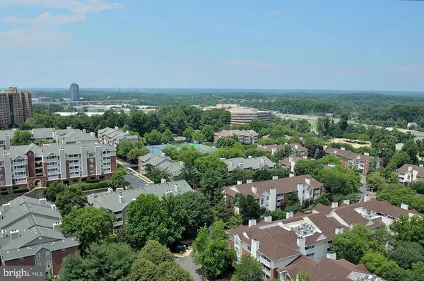 an aerial view of a city with lots of residential buildings and mountain view in back
