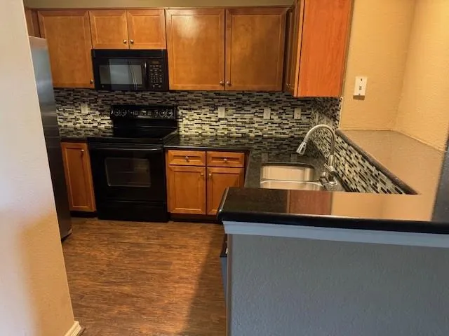 a kitchen with granite countertop a stove and a sink
