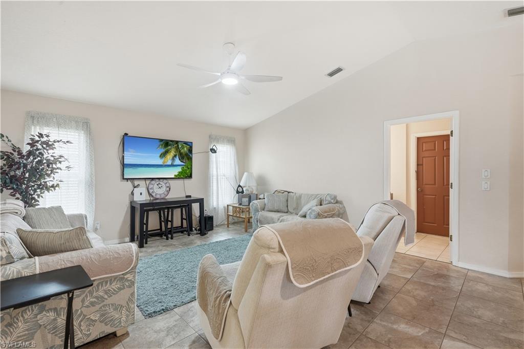 25378 Rupert Road Punta Gorda, FL 33983 - Photo 24 of 50 Living area featuring vaulted ceilings, tile flooring, a ceiling fan with integrated lighting, and multiple windows with blinds