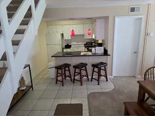 a kitchen with granite countertop a sink dishwasher stove and white cabinets