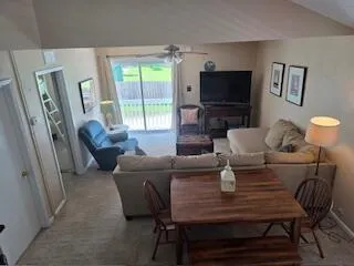 a living room with furniture a flat screen tv and a window