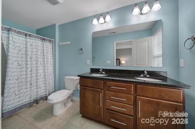 a bathroom with a toilet a sink and mirror