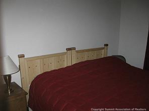 2793 Singletree Road Hartsel, CO 80449 - Photo 14 of 18 a bed sitting in a bedroom next to a lamp