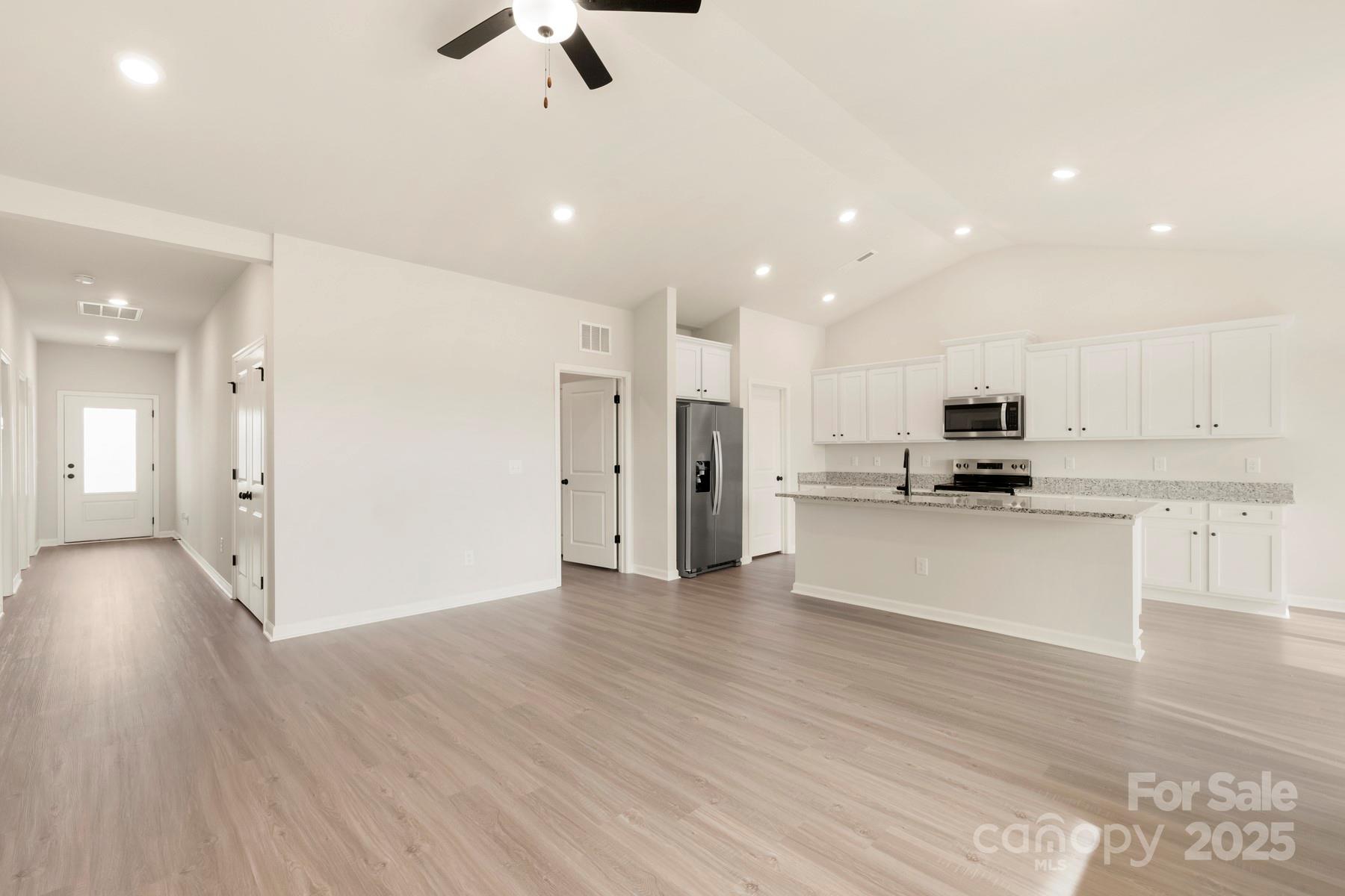 290 Limestone Terrace Apex, NC 27523 - Photo 4 of 11 a view of kitchen with stainless steel appliances refrigerator stove microwave and cabinets