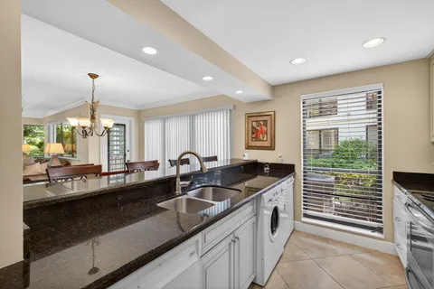 a kitchen with granite countertop a sink and a refrigerator