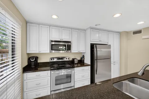 a kitchen with a refrigerator sink and cabinets