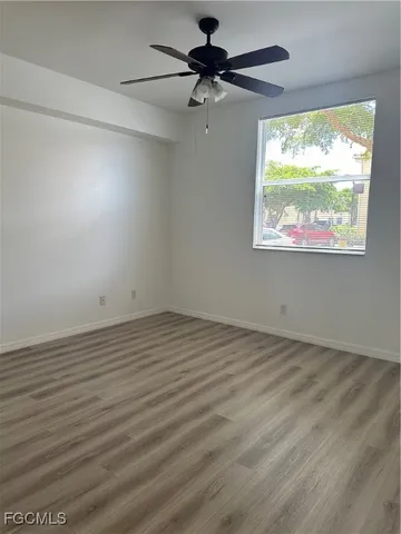 an empty room with a window and a ceiling fan