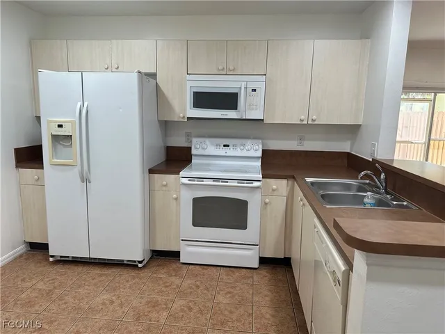 a kitchen with white cabinets and white appliances