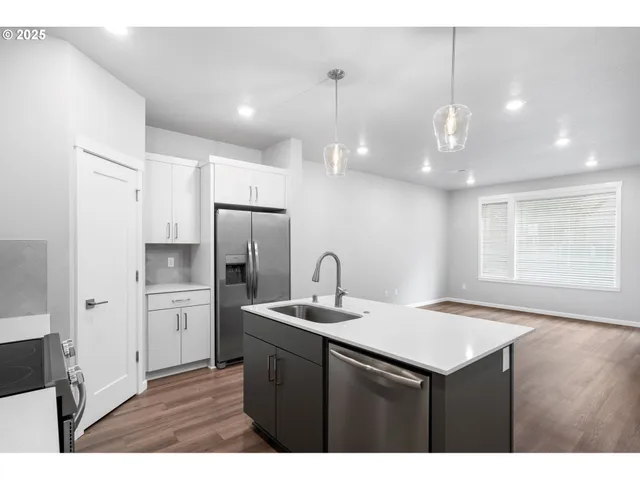 a kitchen with kitchen island a sink stainless steel appliances and cabinets