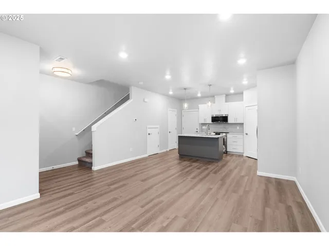 a view of a kitchen with wooden floor and a sink