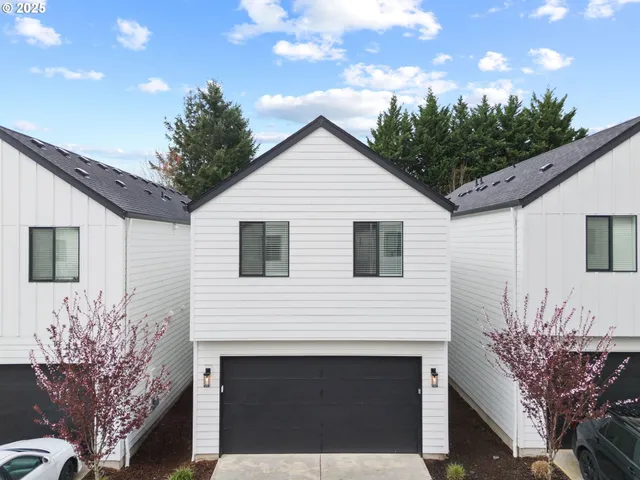a view of house with a yard and potted plants