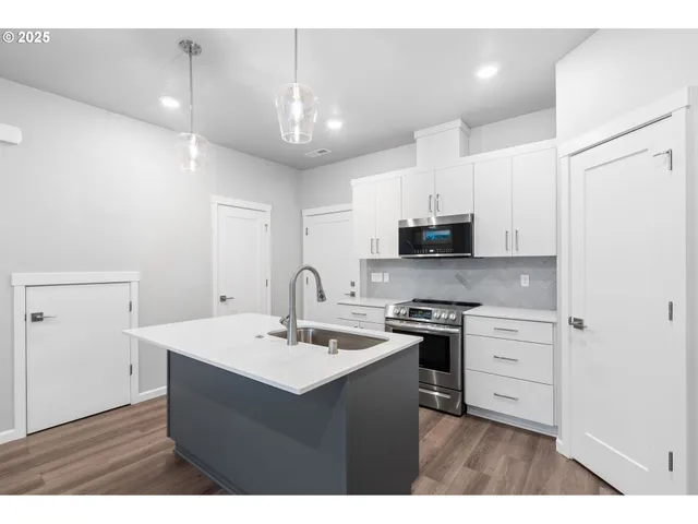 a kitchen with stainless steel appliances a sink stove and refrigerator