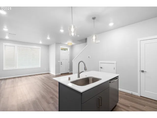 a kitchen with a sink a counter space and wooden floor