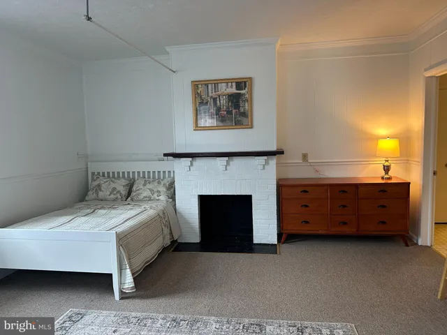 a spacious bedroom with a bed and a fireplace