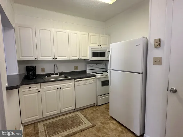 a kitchen with appliances a refrigerator and cabinets