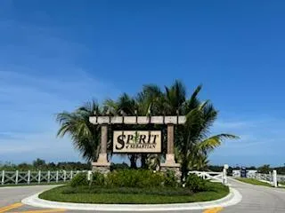 a sign board with a house in the background
