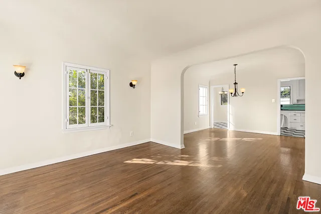 a view of a livingroom with wooden floor and a large window