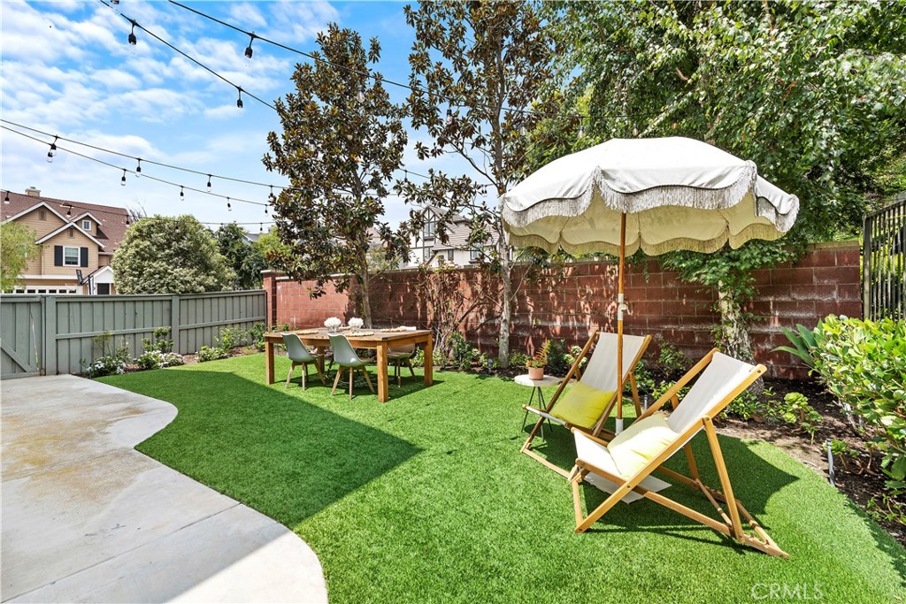 8 Bluewing Lane Ladera Ranch, CA 92694 - Photo 29 of 55 a view of a backyard with table and chairs under an umbrella
