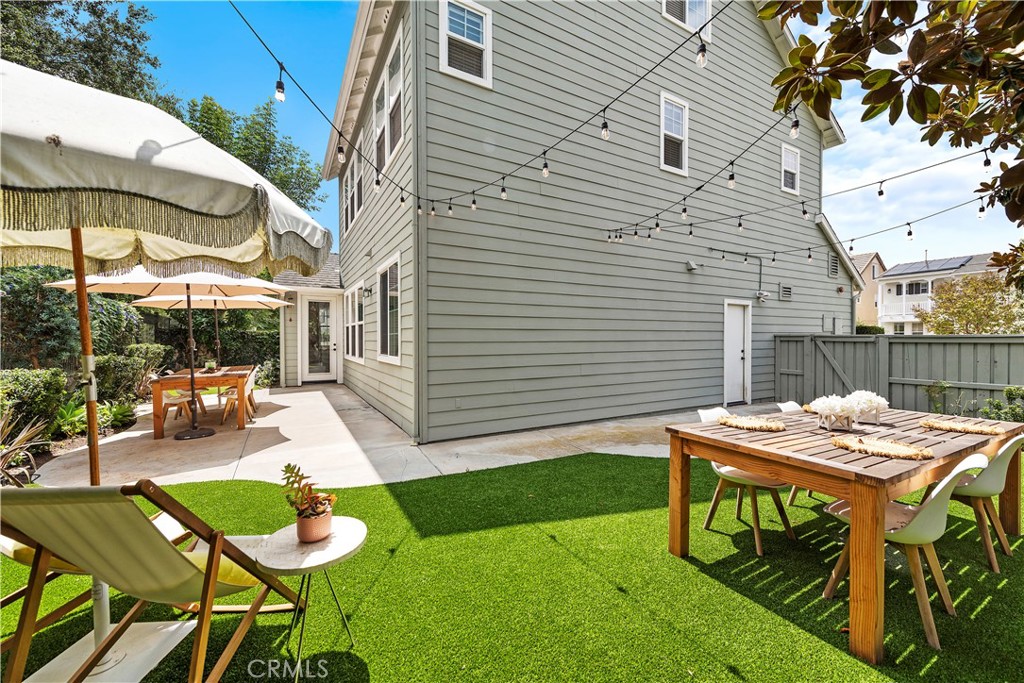 8 Bluewing Lane Ladera Ranch, CA 92694 - Photo 30 of 55 a view of a patio with table and chairs under an umbrella with a barbeque grill and plants