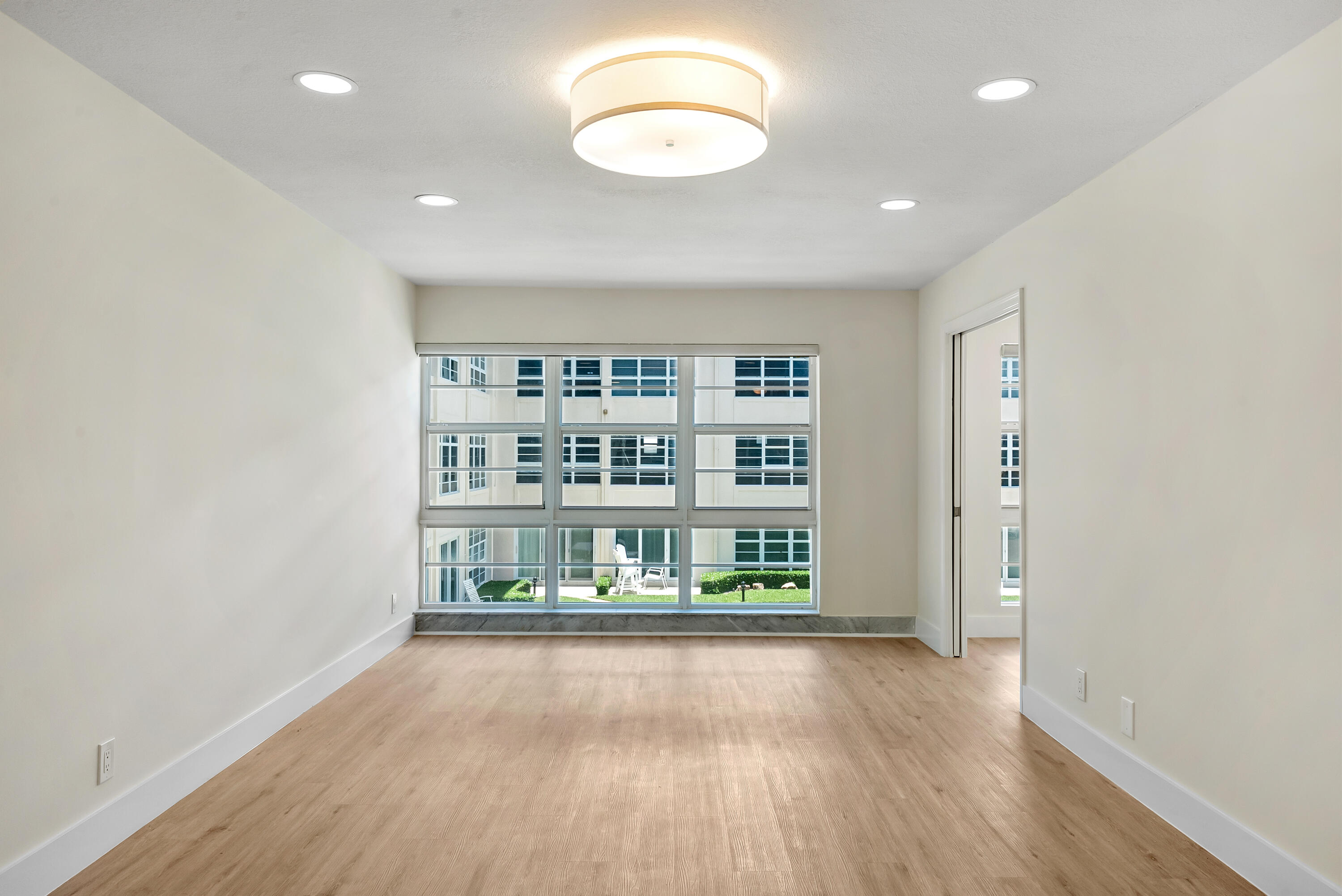 3851 North Ocean Boulevard, Unit 211 Gulf Stream, FL 33483 - Photo 7 of 19 an empty room with wooden floor and window