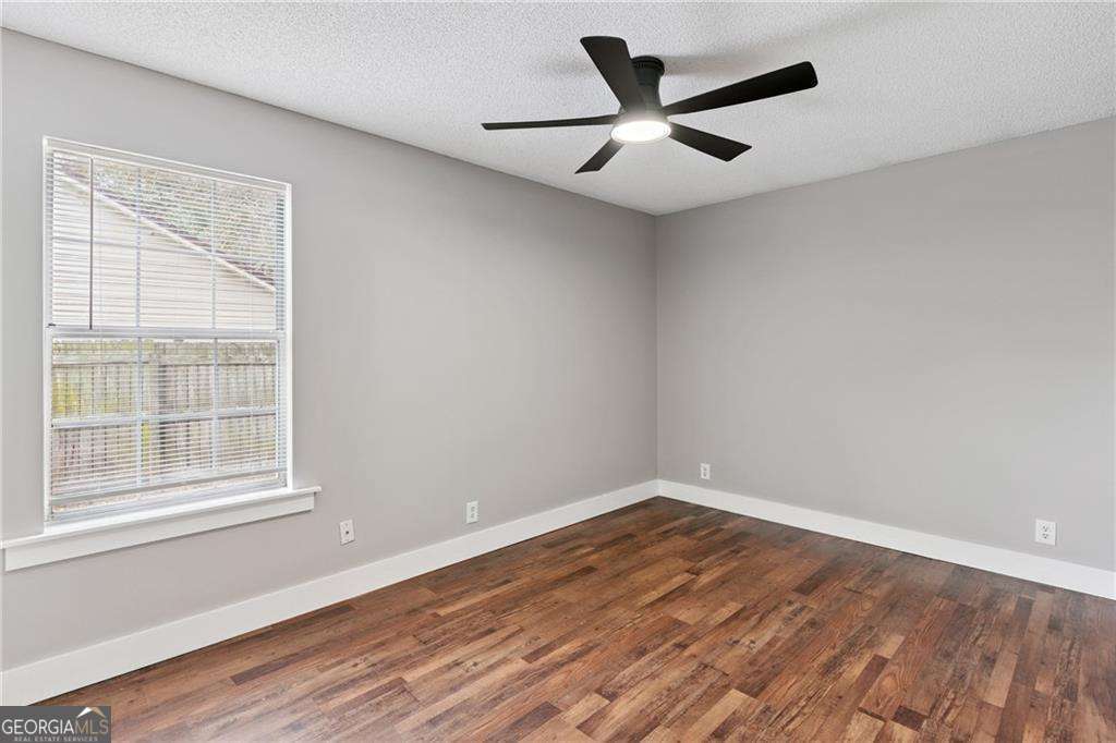 336 Terrapin Trail Brunswick, GA 31525 - Photo 14 of 24 an empty room with wooden floor and windows