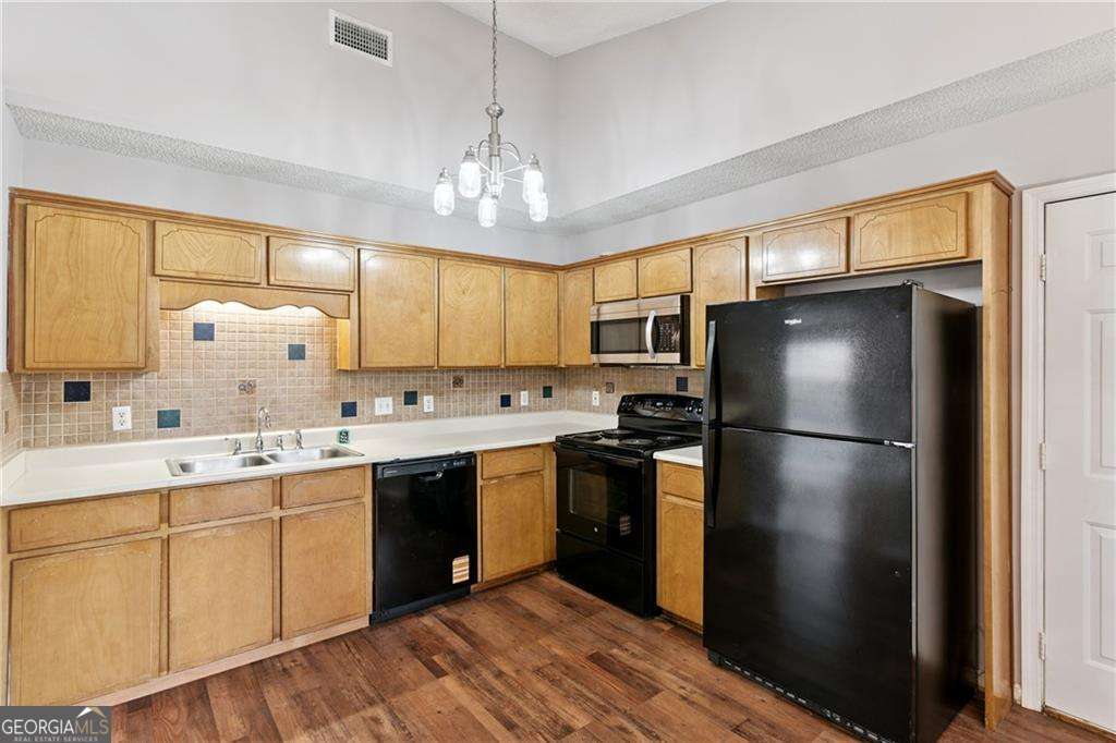 336 Terrapin Trail Brunswick, GA 31525 - Photo 8 of 24 a kitchen with stainless steel appliances granite countertop a refrigerator a sink dishwasher a stove and white cabinets with wooden floor