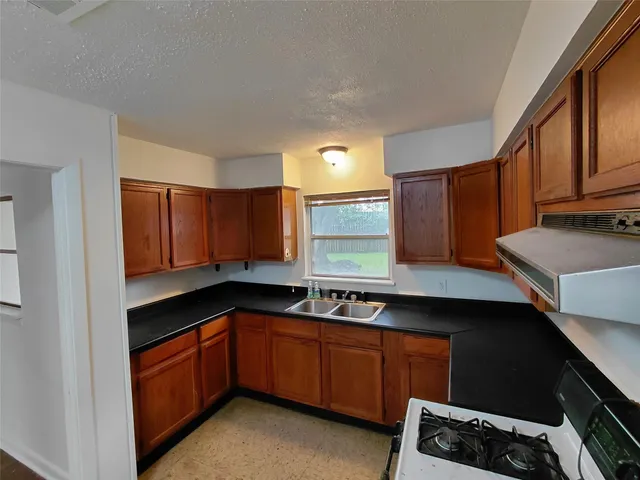 a kitchen with stainless steel appliances granite countertop a sink stove and cabinets