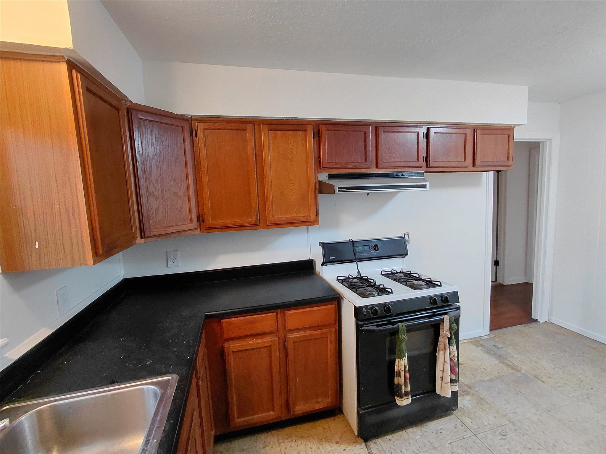 201 Delta Street Pasadena, TX 77506 - Photo 18 of 19 a kitchen with stainless steel appliances granite countertop a stove a sink and a microwave