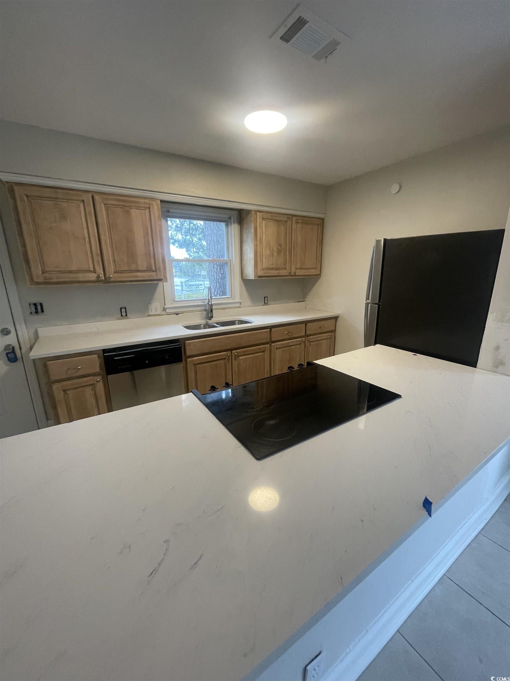 4641 Socastee Boulevard, Unit E1 Myrtle Beach, SC 29588 - Photo 3 of 20 Kitchen with appliances with stainless steel finishes, tile patterned floors, and light stone countertops