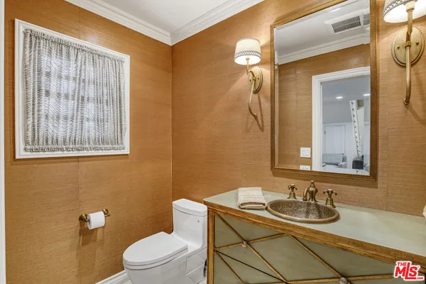 a bathroom with a toilet a sink and mirror